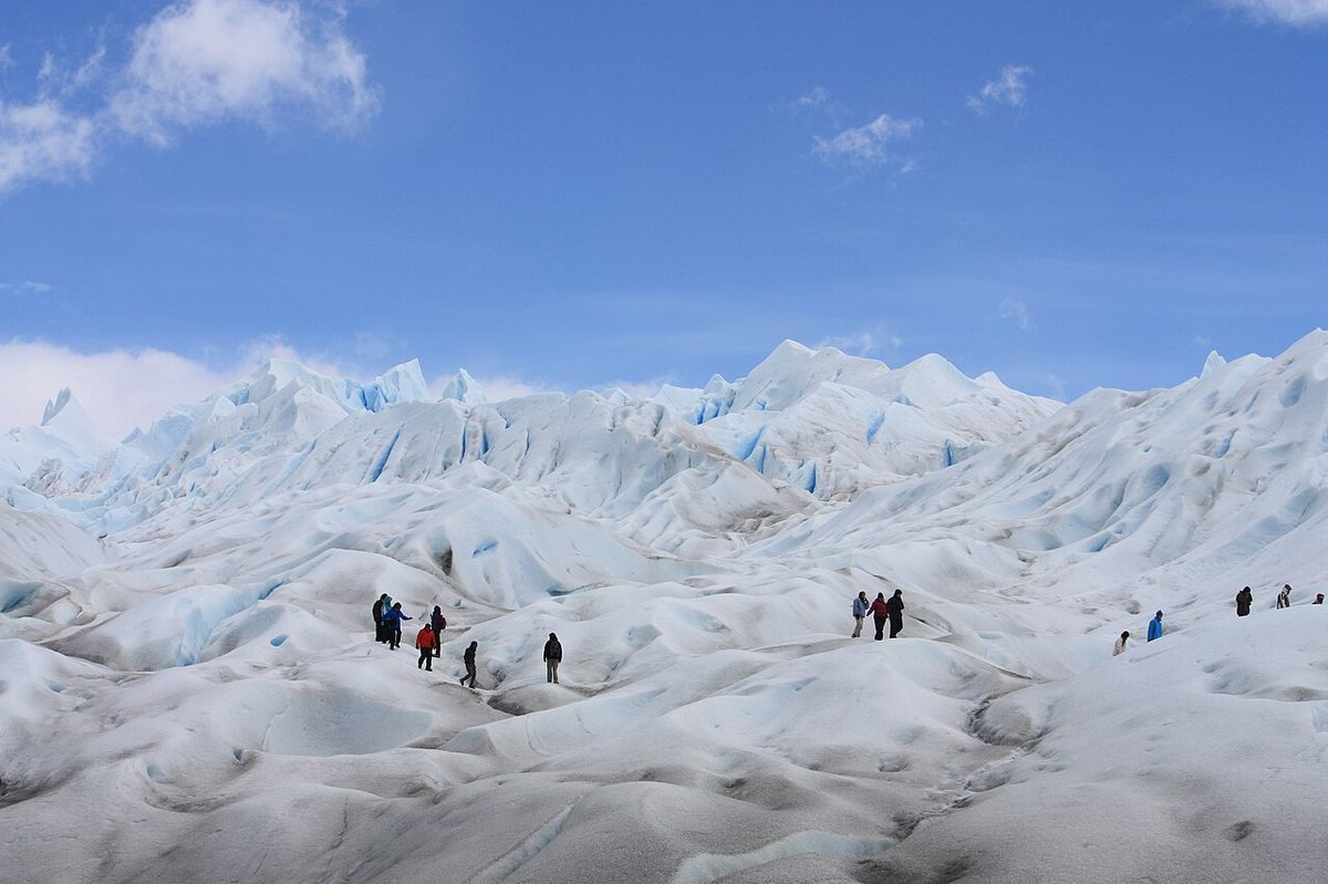 Hikers in crampons compared for Perito Moreno mini trekking vs big ice glacier tours