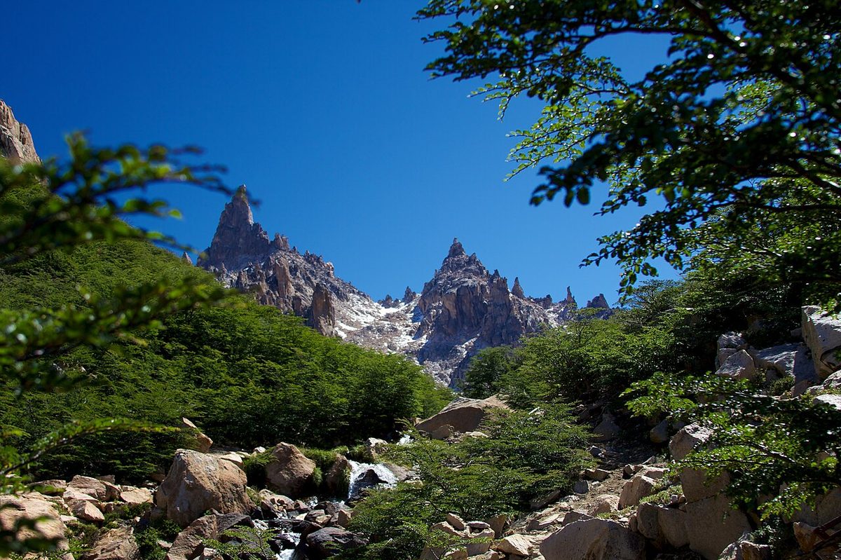 Refugio Frey beside Laguna Toncek ringed by granite spires, a classic Bariloche hiking destination in Patagonia