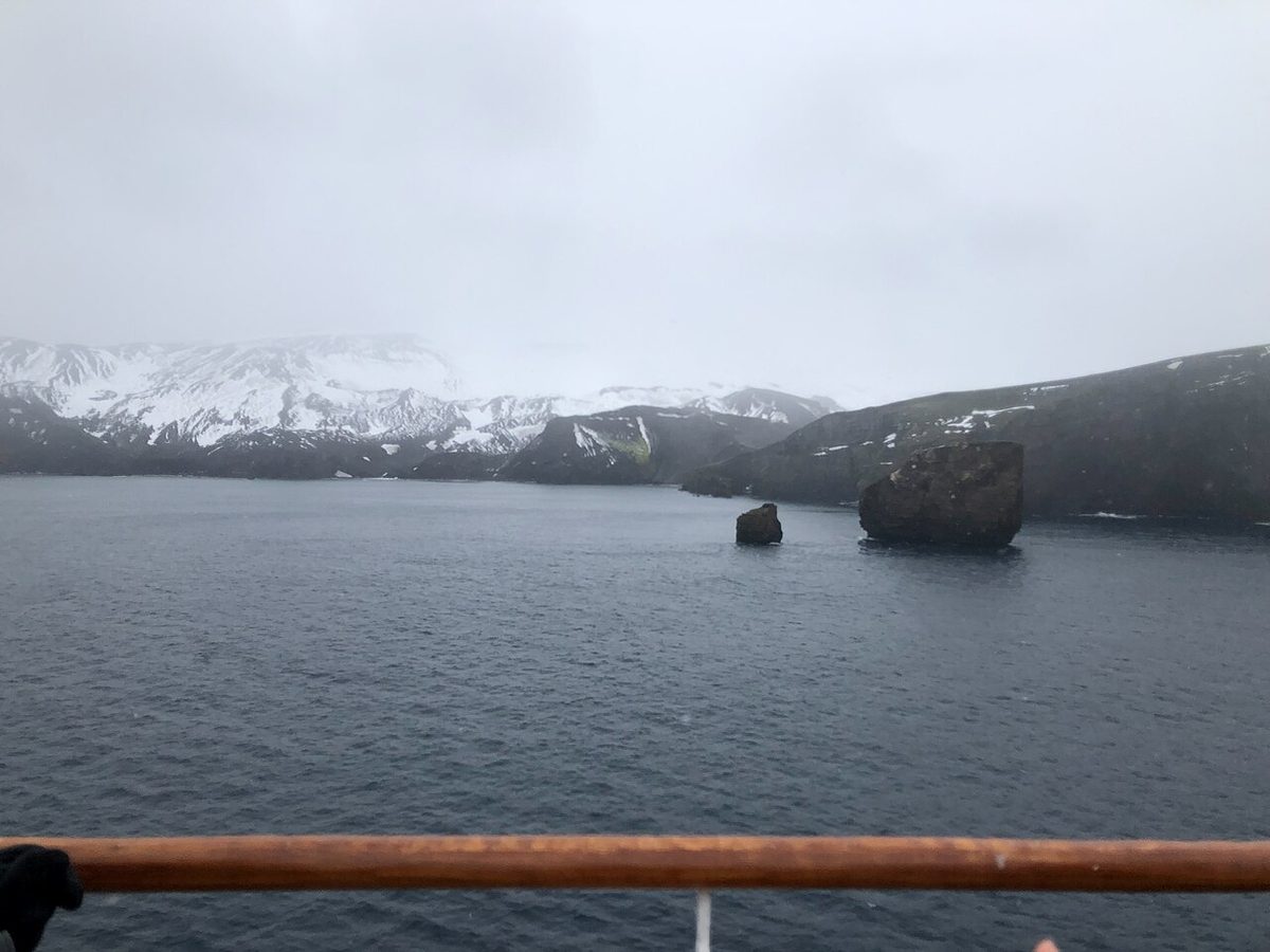 A small expedition cruise ship among icebergs in Antarctica