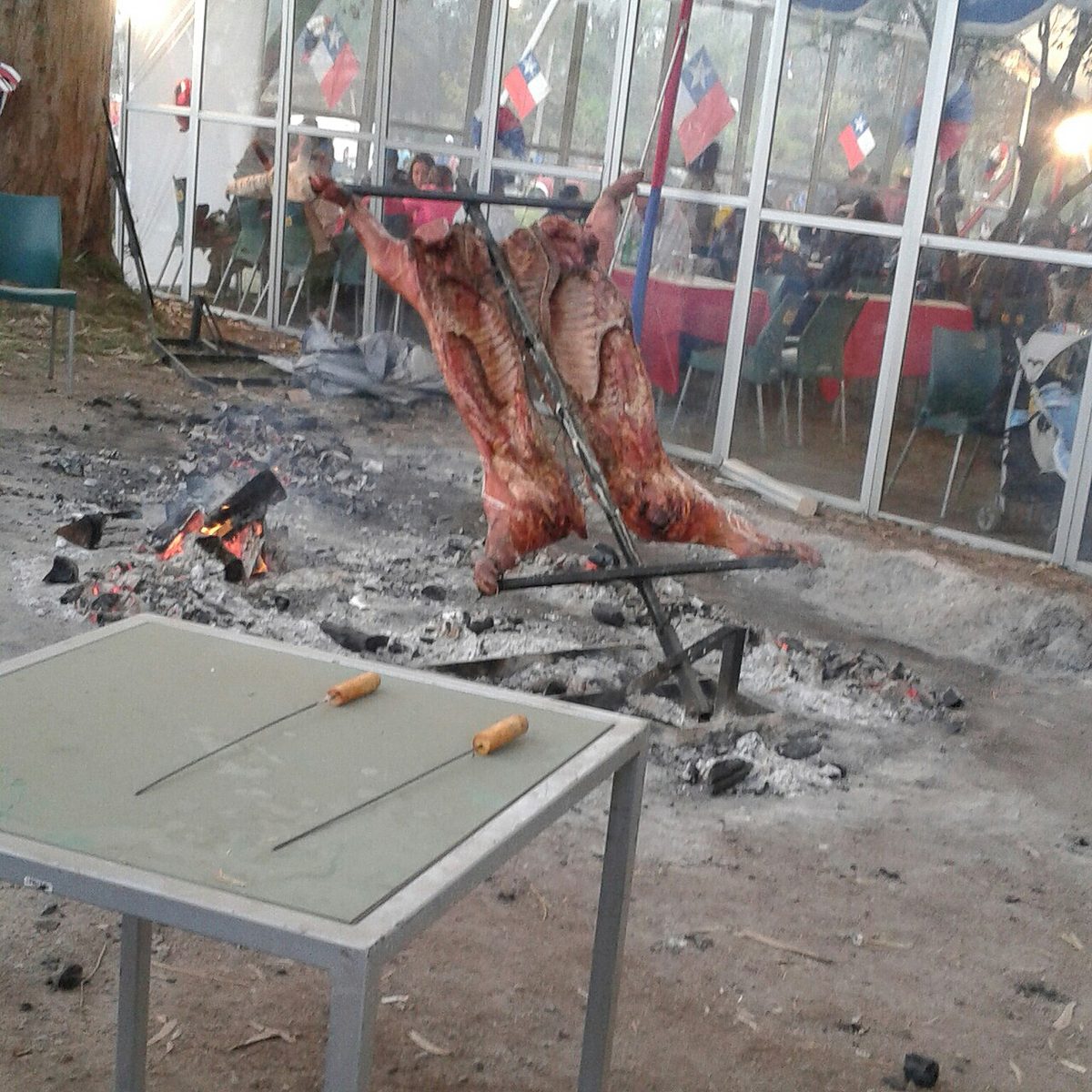 Meat roasting over open flames, similar to the slow-fire cooking style used for Patagonia asado.