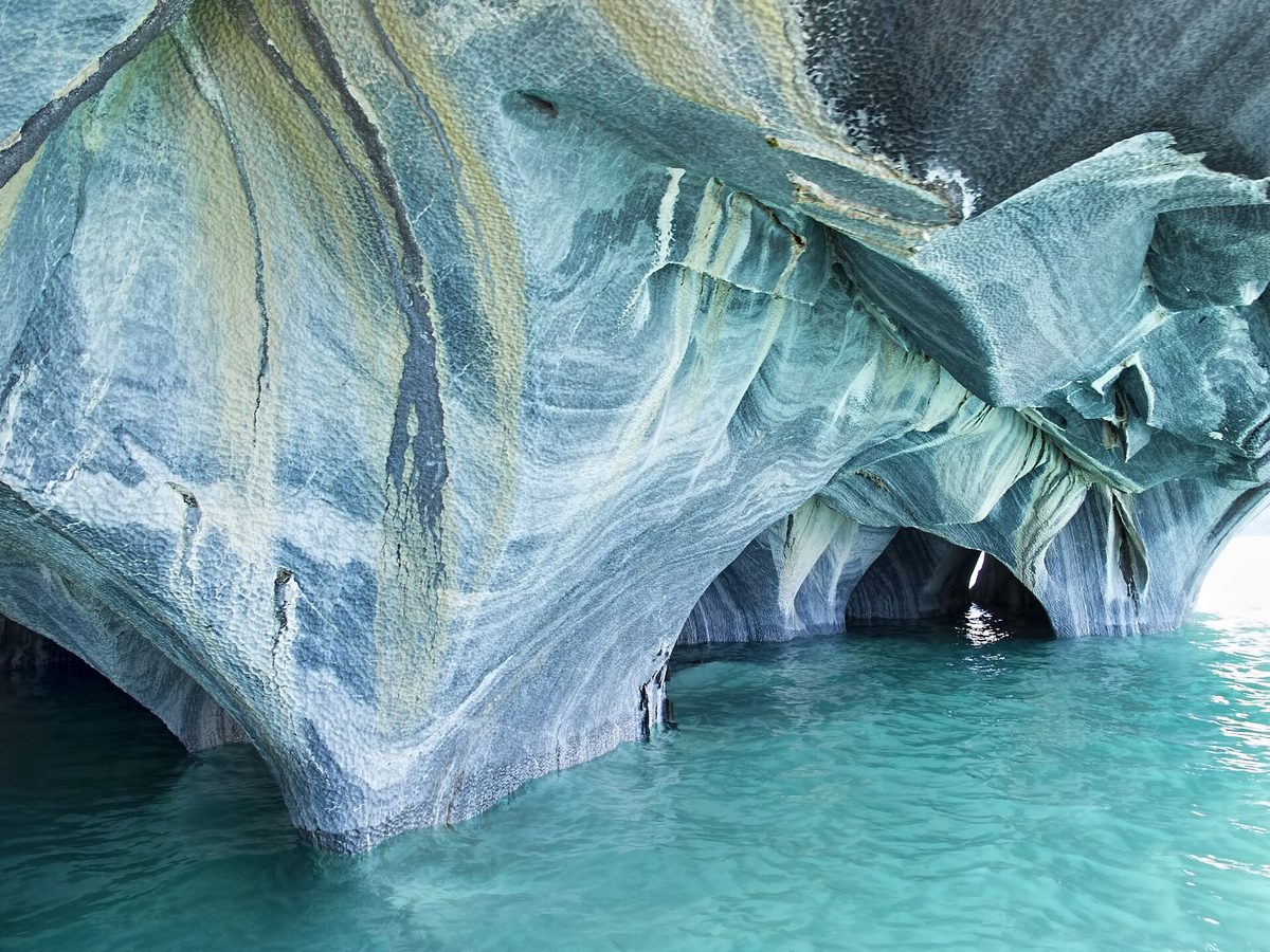 Swirled marble rock formations above turquoise water on Lago General Carrera