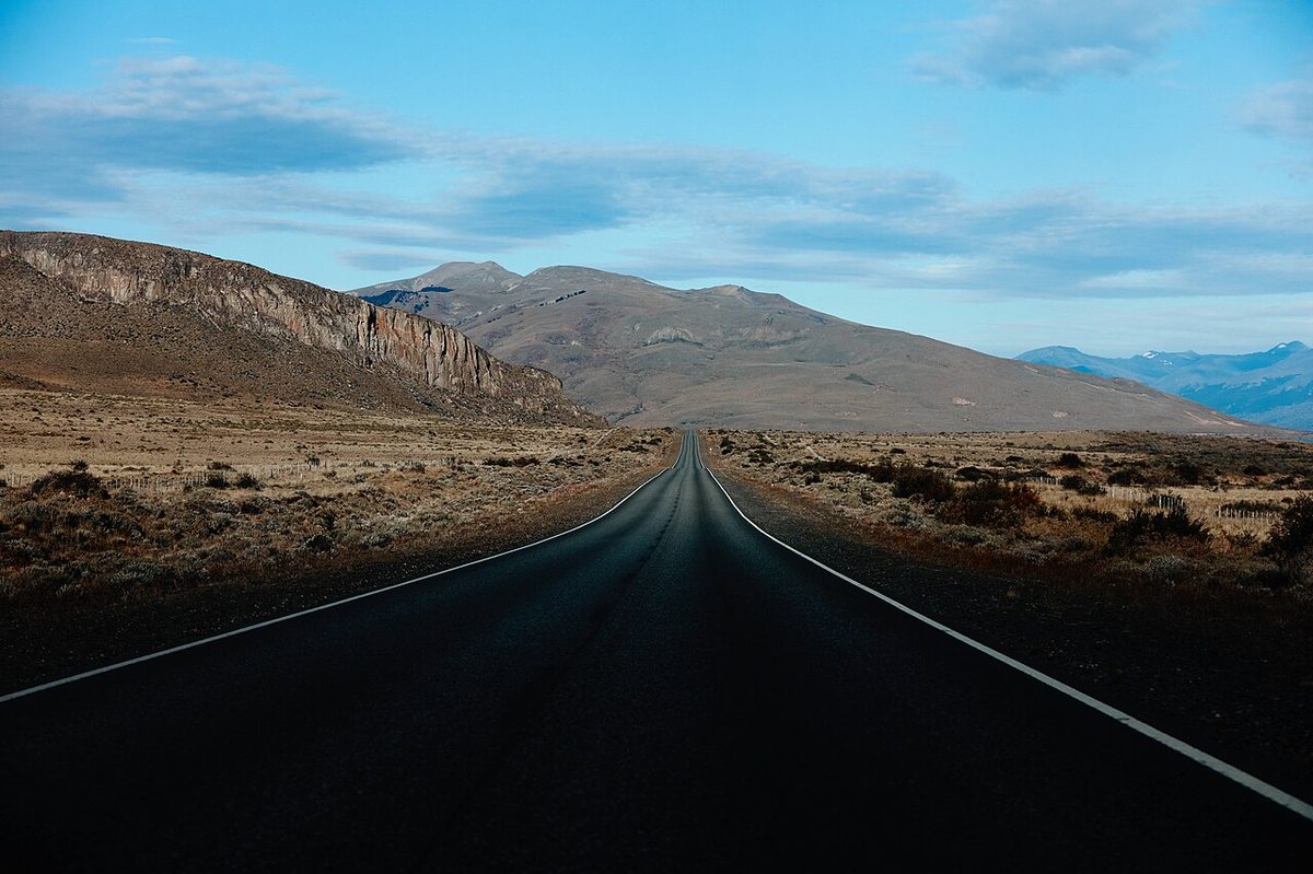 The paved road across the open steppe on the approach to El Calafate, with the Andes on the horizon