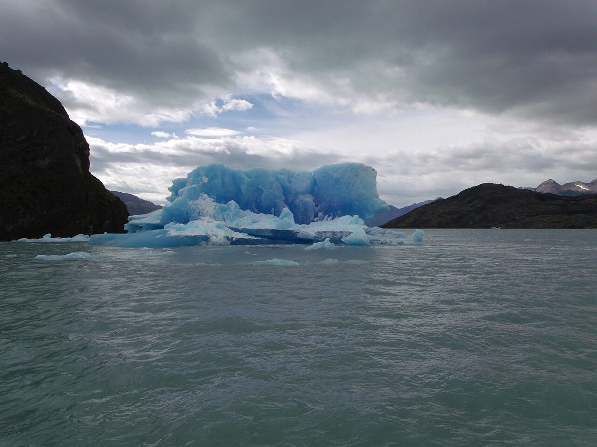 A large blue iceberg from the Upsala Glacier floating on Lago Argentino under heavy cloud