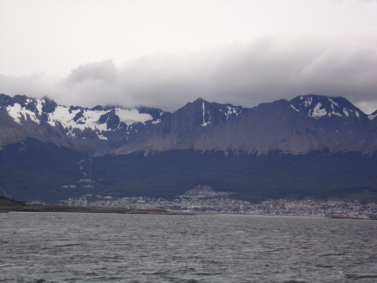 Ushuaia along the shore of its bay below the snowy Martial range, seen from across the water