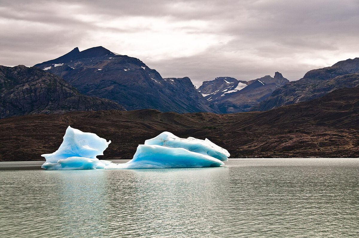 Blue icebergs on Lago Argentino below dark mountains in Los Glaciares National Park
