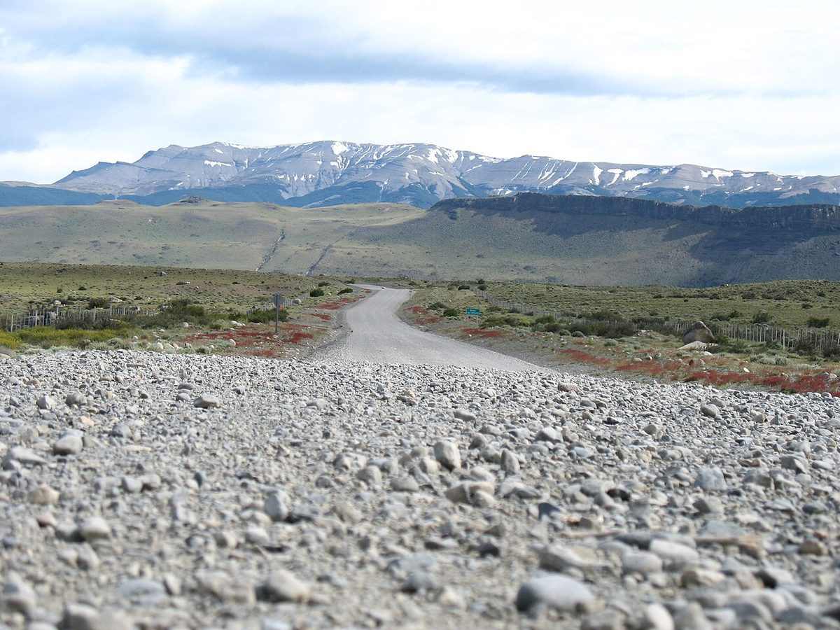 A gravel road between Puerto Natales and Torres del Paine running towards a line of snow-dusted mountains