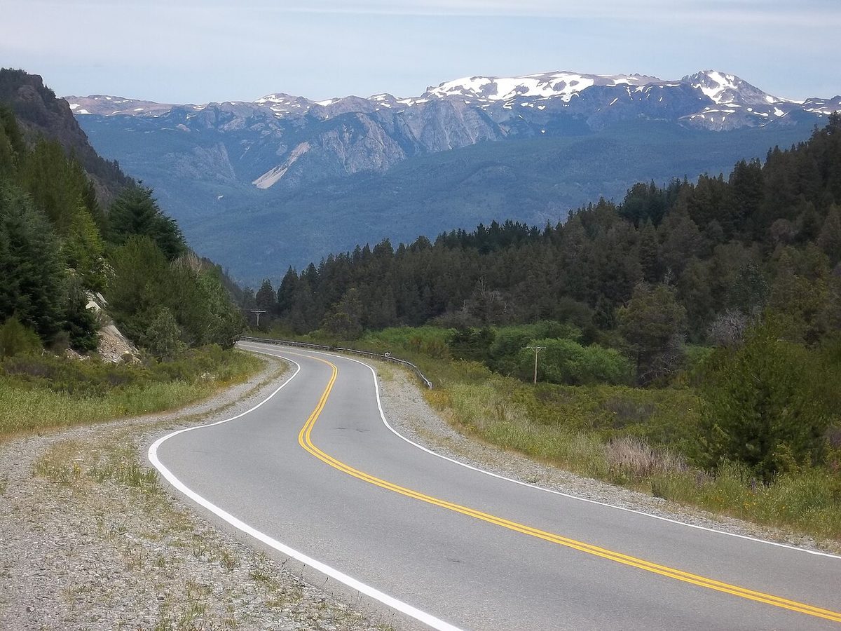 Ruta 40 curving down through forested mountains in northern Patagonia near kilometre post 1930